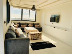 - un salon avec un canapé et une table dans l'établissement SUNFLOWER Apartments, à Agadir nʼ Aït Sa