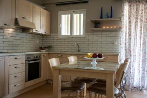 a kitchen with a table with a bowl of fruit on it at Nest Aegina Apartments in Perdika