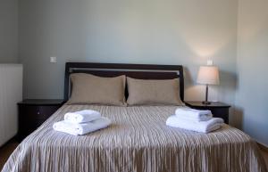 a bed with two towels sitting on top of it at Nest Aegina Apartments in Perdika