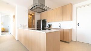 a kitchen with wooden cabinets and a black appliance at Brand New Condo Aria Ocean 614 by Kivoya in Nuevo Vallarta 