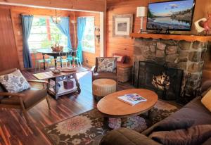 Una sala de estar con chimenea y una mesa. en A Sweet Pine Cabin - Adorable retro home in a peaceful residential neighborhood, en Big Bear City
