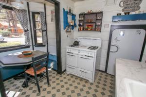 cocina con mesa, fogones y nevera en A Sweet Pine Cabin - Adorable retro home in a peaceful residential neighborhood, en Big Bear City 10 fotos más
