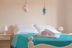 a bed with towels and a hat on it at Ancóramare in Stintino