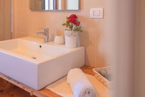a bathroom with a sink and a vase with a flower on it at Ancóramare in Stintino