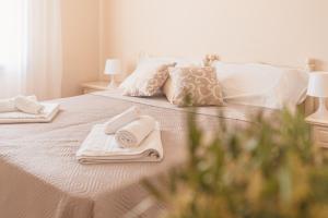 a white bed with towels and pillows on it at Ancóramare in Stintino