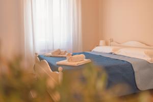 a bedroom with two beds with towels on the bed at Ancóramare in Stintino