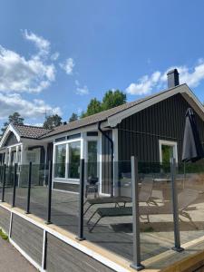 a house with a deck with an umbrella at Tallhöjden - Stor villa med bastu! in Svärtinge