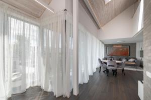 uma sala de jantar com cortinas brancas e uma mesa em Luxury 2 BD Apartment with terrace by Hostlovers em Kaunas