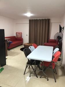 uma sala de estar com uma mesa branca e cadeiras vermelhas em شاليه 120/202 مارينا دلتا em Al Ḩammād