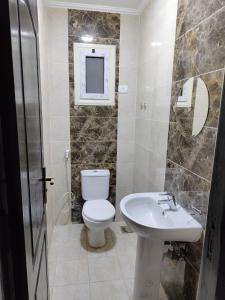 a bathroom with a toilet and a sink at شاليه 120/202 مارينا دلتا in Al Ḩammād
