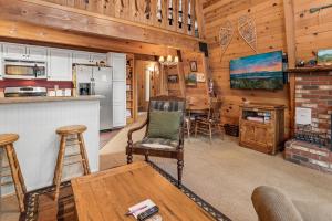 una cocina y una sala de estar en una cabaña con bar en Zen Den - Beautiful A-frame cabin with classic brick wood burning fireplace and a hot tub, en Big Bear Lake