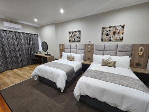 um quarto de hotel com duas camas e um sidx sidx sidx azeb em Luxe Musgrave Boutique Hotel em Durban