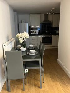 a kitchen with a table and chairs with flowers on it at PRECIOUSHOUSELUXURYSTAY in London