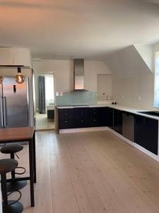 uma grande cozinha com piso em madeira e uma mesa em Fin lägenhet i centrala Leksand em Leksand