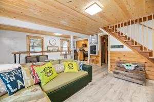 uma sala de estar com um sofá verde e uma escada em Yoda Maple Cabin- Awesome cabin with great amenities, you can feel the warmth of this charming cabin em Sugarloaf