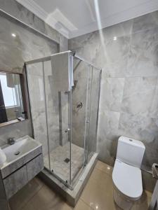 a bathroom with a shower and a toilet and a sink at Luxe Musgrave Boutique Hotel in Durban