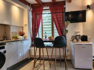 une petite cuisine avec une table et deux chaises dans l'établissement Lovely Studio in center of Bucharest, à Bucarest