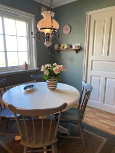 a dining room table with a vase of flowers on it at Shared Farmhouse in Stavanger