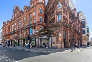 Un gran edificio de ladrillo en la esquina de una calle. en Piccadilly Haven, Flat in London VR12, en Londres