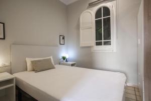 un letto bianco in una stanza con finestra di P1PAR1001 - Wonderfull aparment in Paralel a Barcellona