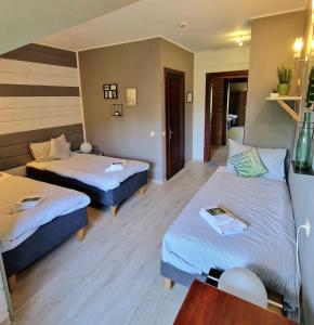 Habitación de hotel con 2 camas y mesa en Green bear en Līgatne