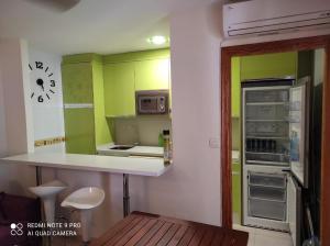 馬薩龍港的住宿－URBANIZACION PUEBLO SALADO BEACH，厨房配有绿色橱柜和白色台面