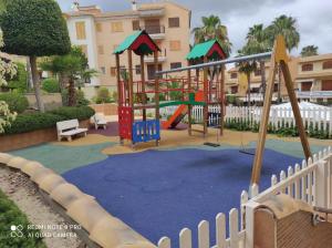 um parque infantil em frente a um edifício em URBANIZACION PUEBLO SALADO BEACH em Puerto de Mazarrón