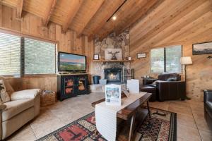 a living room with a fireplace in a log cabin at Wolf View Lodge - Adorable and modern cabin with well-appointed mountain decor in Big Bear Lake
