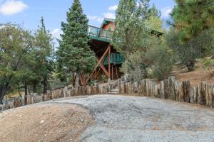 a house on a hill with a wooden fence at Wolf View Lodge - Adorable and modern cabin with well-appointed mountain decor in Big Bear Lake