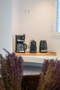 a shelf with three coffee pots and pans on it at mikro Thama in Kámbos