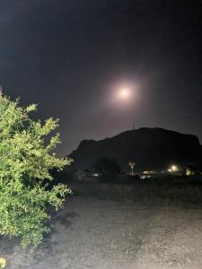 a moon rising over a mountain at night at White rose in Kámpos