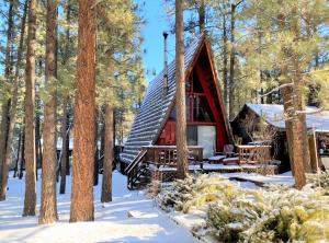 uma cabana na floresta na neve em A-Frame of Mind - Nice cozy cabin great view to the outdoors and peaceful em Big Bear City