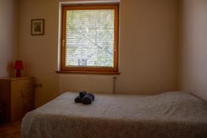 Ein ausgestopftes Tier sitzt auf einem Bett in einem Schlafzimmer in der Unterkunft La casa verde in Bled-Rečica