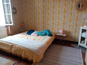 Un dormitorio con una cama con almohadas. en Les Toiles du Figuier, en Espéraza