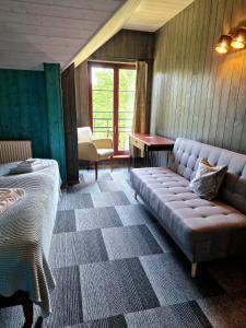 a room with a couch and a bed and a table at Green bear in Līgatne