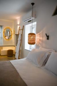 1 dormitorio con cama blanca y espejo en mikro Thama en Kámbos