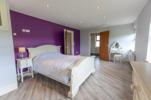 的住宿－Bellair House，卧室配有白色的床和紫色墙壁