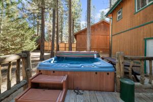 Un jacuzzi en una terraza junto a una casa. en Abe's Cool Cabin - Nice luxury home with a game room, hot tub, and pool table, en Big Bear Lake
