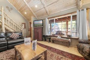 una sala de estar con un sofá y una mesa en Abe's Cool Cabin - Nice luxury home with a game room, hot tub, and pool table, en Big Bear Lake