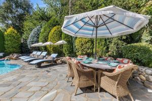 a table with an umbrella and chairs next to a pool at Glamorous Cabana in Newburyport