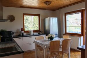 eine Küche mit einem Tisch mit Stühlen und einem Kühlschrank in der Unterkunft La casa verde in Bled-Rečica