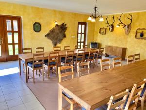 una grande sala da pranzo con tavoli e sedie in legno di Pension Hofberg a Jetřichovice