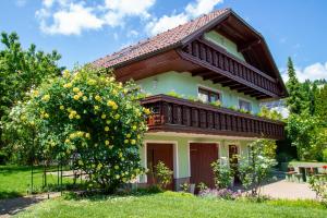 une maison avec un balcon et un arbre dans l'établissement La casa verde, à Bled-Rečica