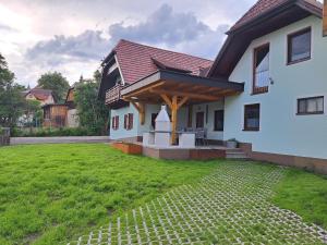 una casa con porche y césped verde en Gasthof Knappenwirt en Mariahof