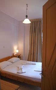 a bedroom with a large white bed with a window at Nikos Apartments A8 in Gialiskari