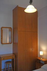 1 dormitorio con armario de madera y espejo en Nikos Apartments A8, en Gialiskari