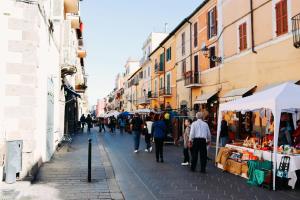 un grupo de personas caminando por una calle con vendedores en SUITE 38, en Campagnano di Roma