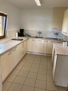 a kitchen with white cabinets and white appliances at Pension Hofberg in Jetřichovice