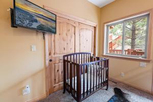 ein Kinderbett in einem Zimmer mit Fenster in der Unterkunft Boulder Bay Chalet Lakefront - Elegantly decorated with Hot Tub and Game Room! in Big Bear Lake