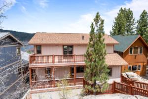 uma casa com um deque na neve em Boulder Bay Chalet Lakefront - Elegantly decorated with Hot Tub and Game Room! em Big Bear Lake